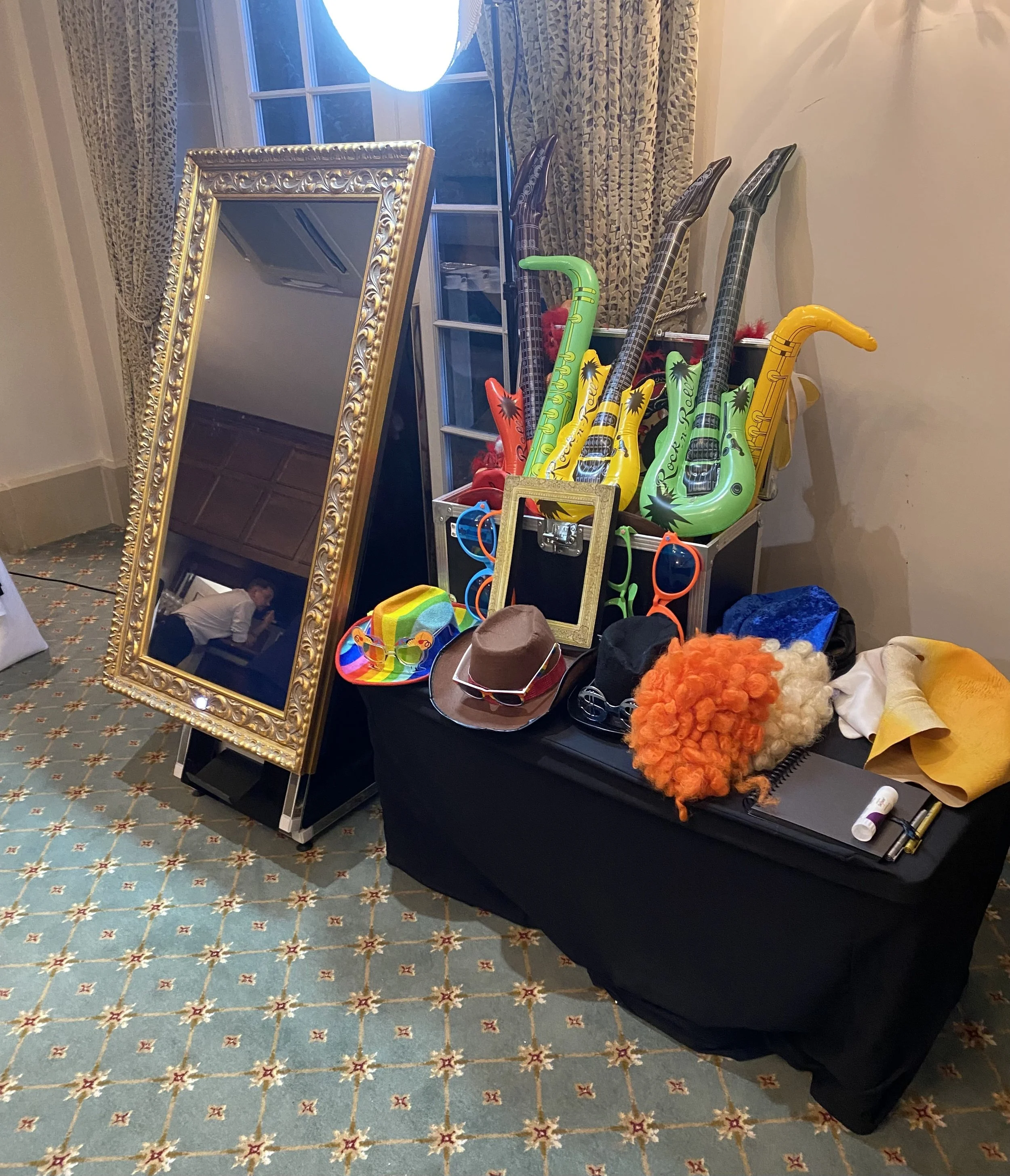 Display of novelty sunglasses, hats, a mirror, costumes, and inflatables resembling different animals and characters.