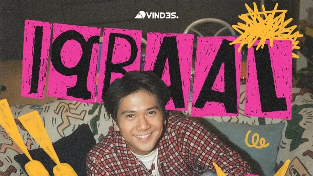 A smiling young man with black hair sitting on a colorful patterned couch, surrounded by bold pink and yellow graphic elements and text that says 'IS FRIEND'.