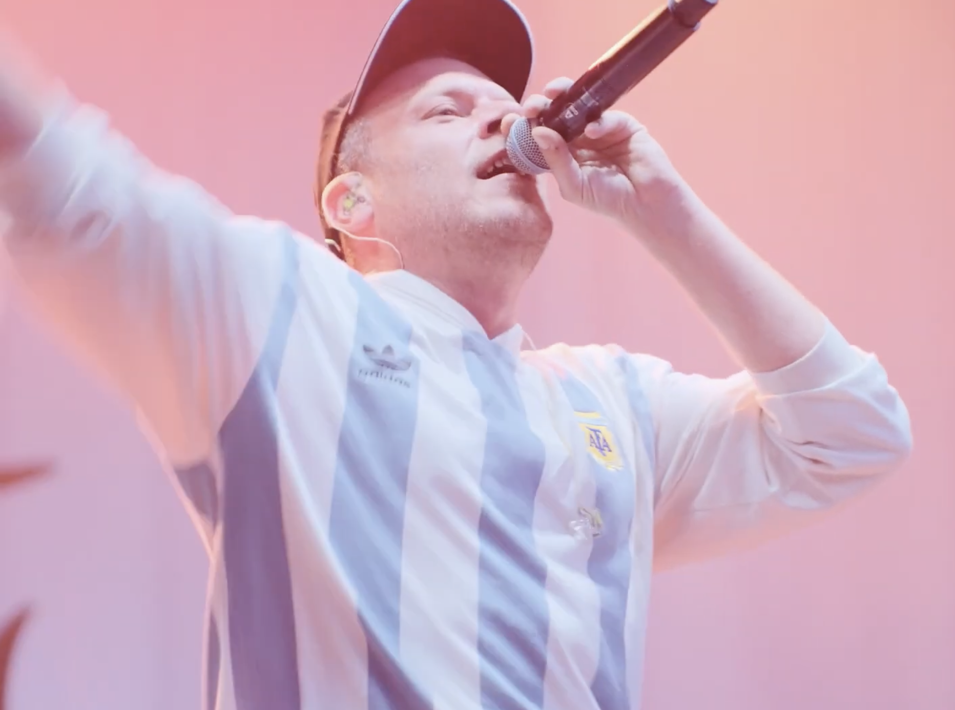 Person singt mit einem Mikrofon, trägt ein Trikot der argentinischen Fußballnationalmannschaft. - Wismar_Marketing