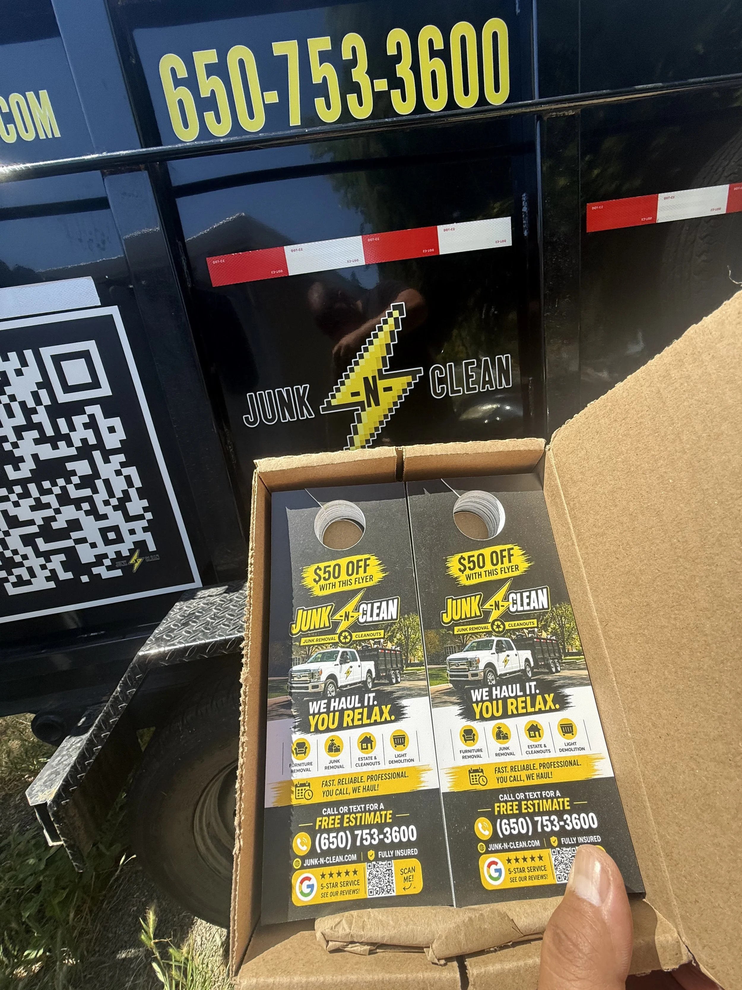 Brochure advertising junk removal services with a yellow lightning bolt logo, offering $50 off with flyer, free estimate, and contact phone number, featuring a white truck with yellow and black accents.