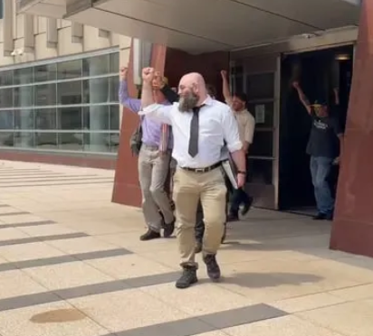 Minnesota 15 Defendants walk out of court building with fists raised in solidarity