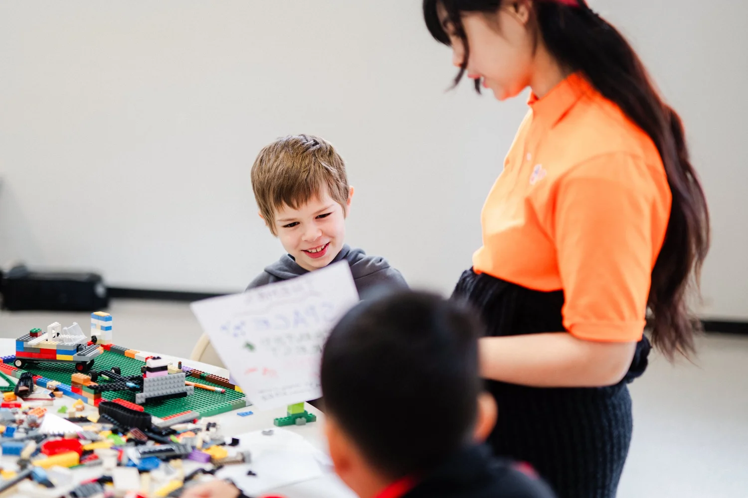A kid and instructor smiling over a LEGO build