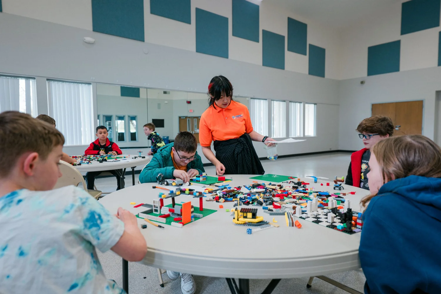 A Journey to STEAM instructor building with a group of kids at a round table