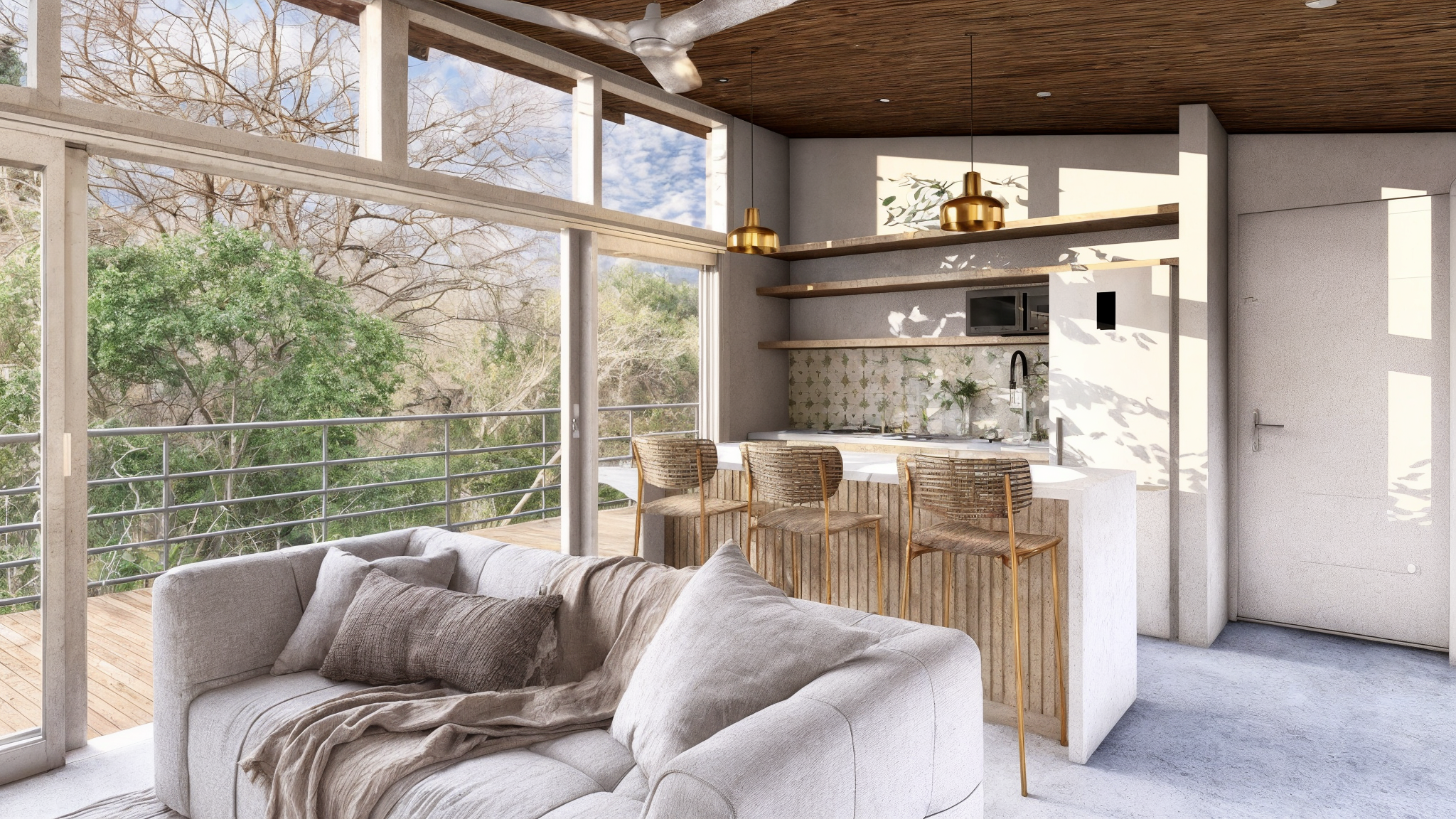 A modern open-plan living space with a sitting area and a kitchen. Large windows offer views of trees outside, allowing natural light to fill the room. The decor features neutral tones, with a wooden ceiling and hanging gold pendant lights over a small kitchen counter with bar stools.