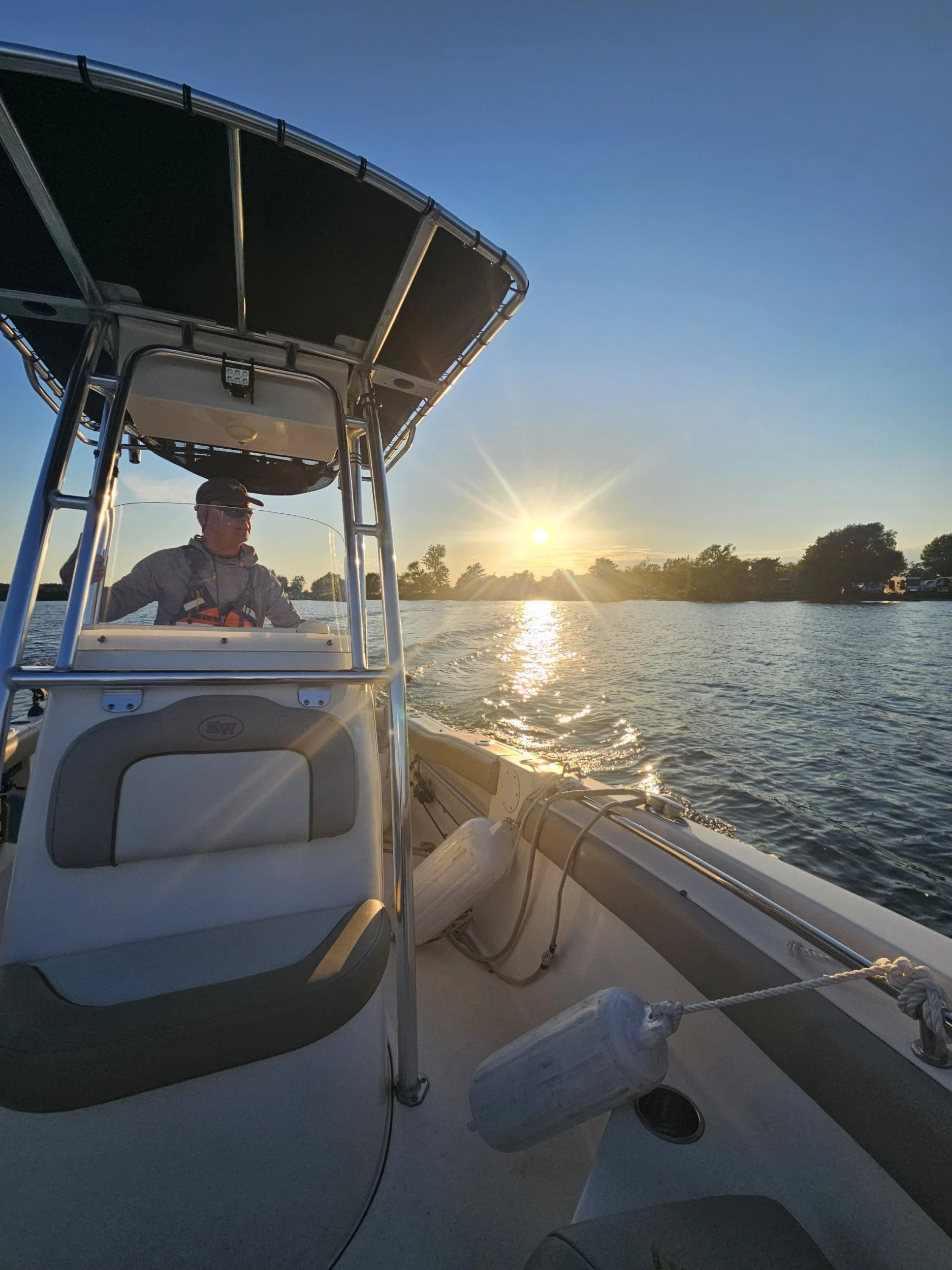 Captain Mark cruising a boat at sunset in Lake Ontario near Sackets Harbor, New York War of 1812 Battlefield