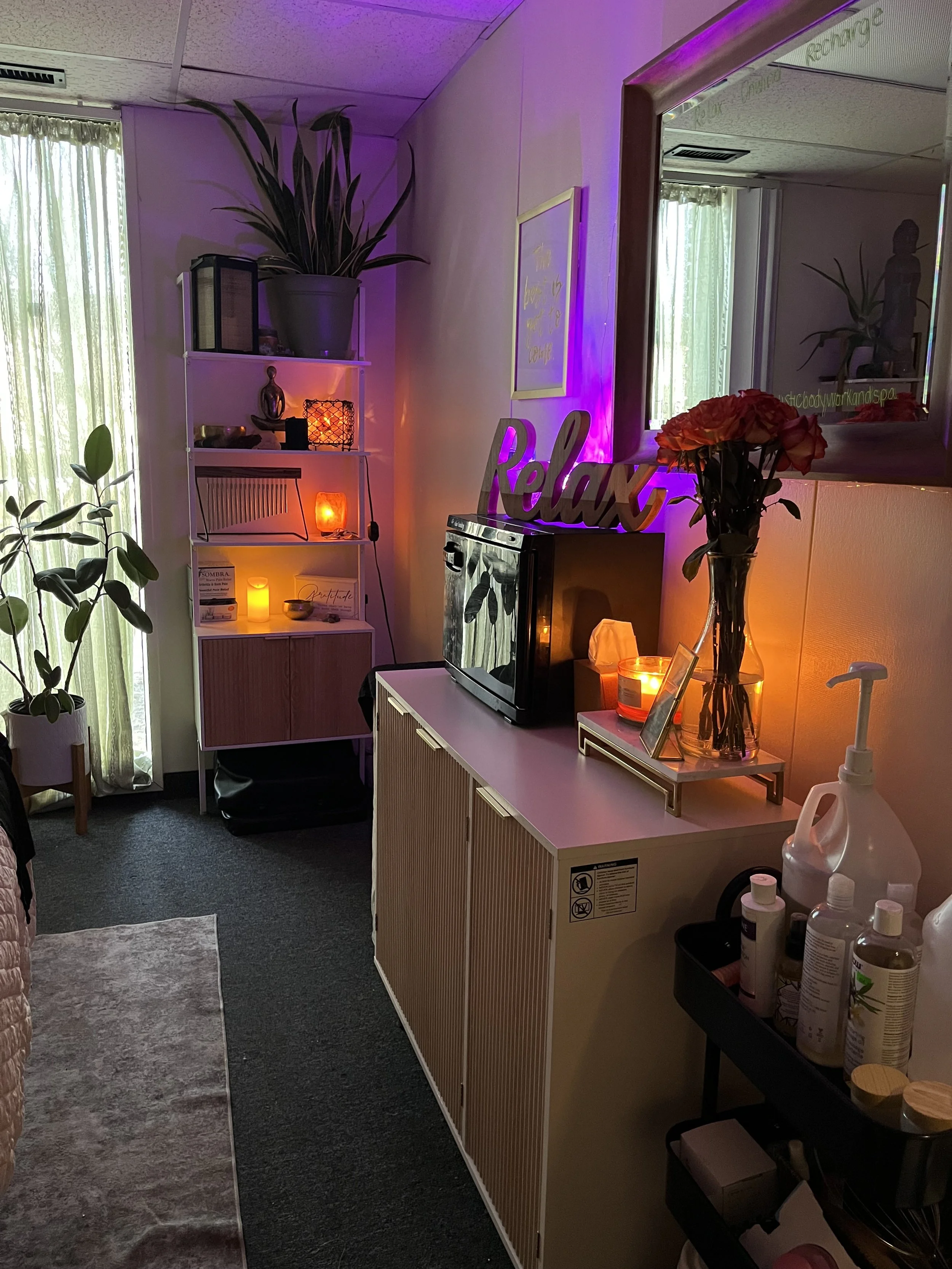 A cozy room decorated with candles, a vase of flowers, a frog figurine, and a