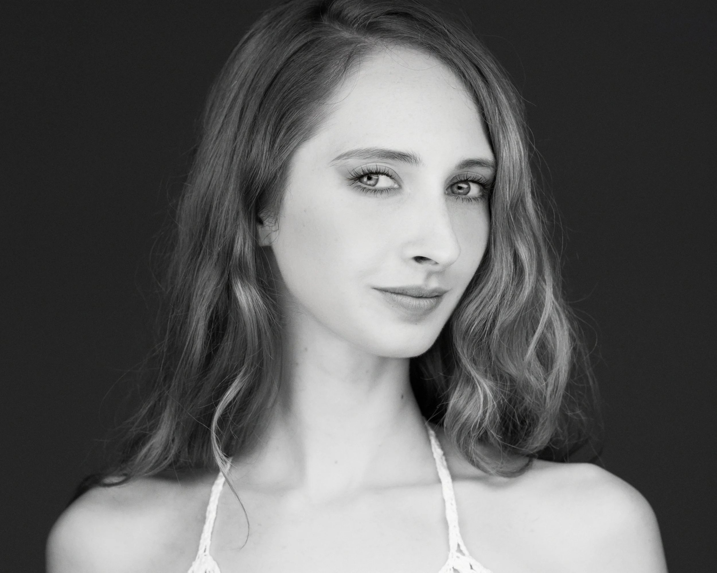 Rick Morgan Photography Manchester CT. Black and white portrait of a young woman with long hair and a halter top, looking at the camera.