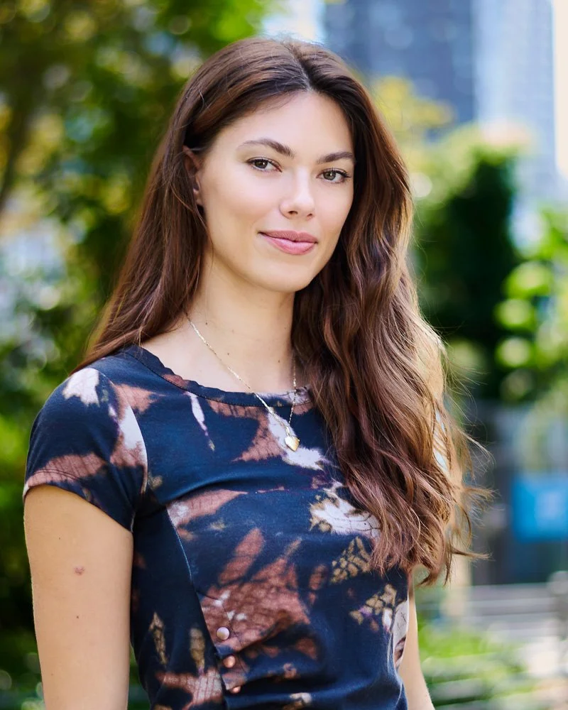 Woman with long brown hair posing outdoors during a natural-light portrait workshop in New York City.