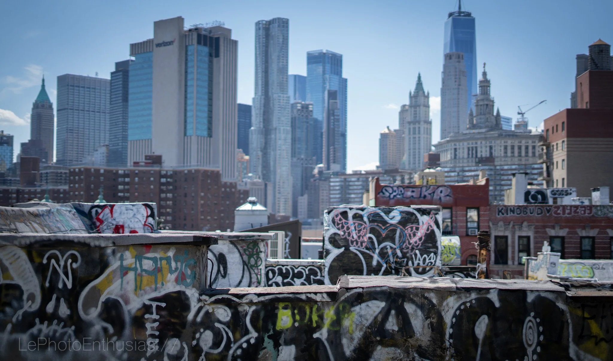 Graffiti-covered rooftop with Brooklyn city skyline in the background, including One World Trade Center.