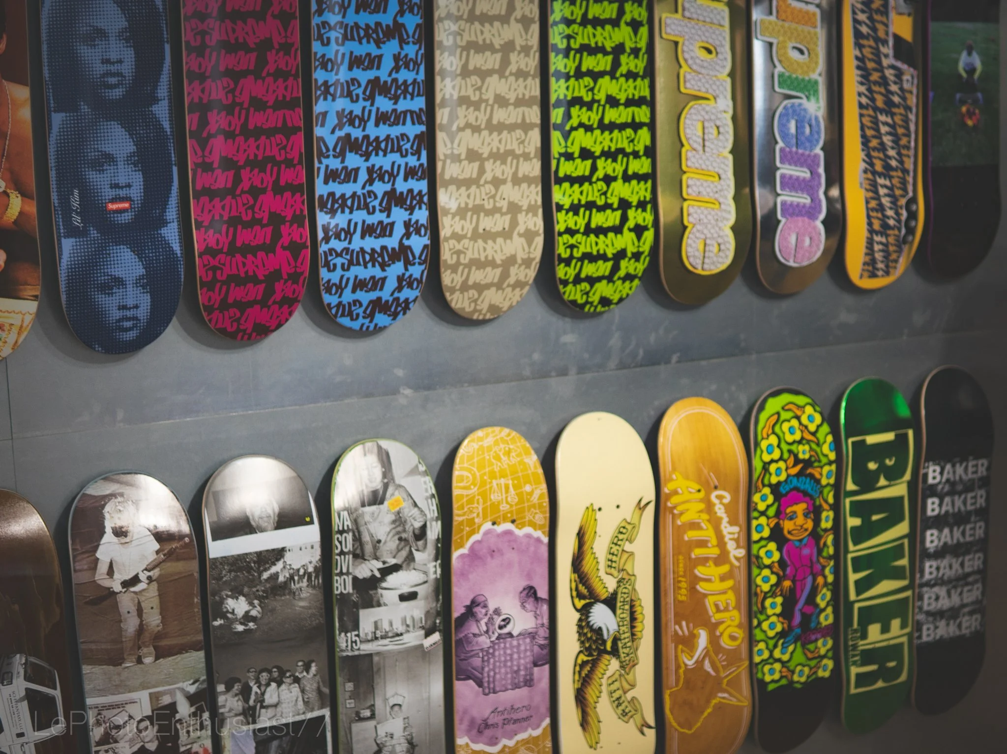 Collection of skateboard decks with various designs and colors displayed vertically.