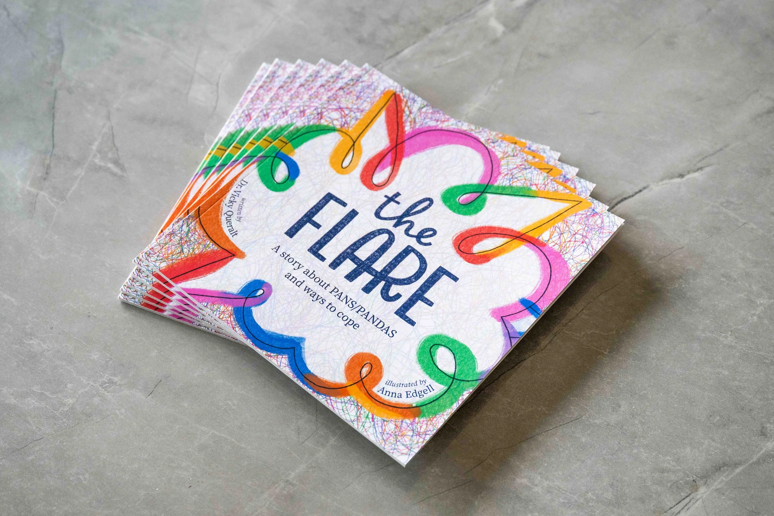 A colorful book titled 'The Flare: A Story About PANS PANDAS and Ways To Cope.  Written by Dr Vicky Queralt (Clinical Psychologist) and illustrated by Anna Edgell