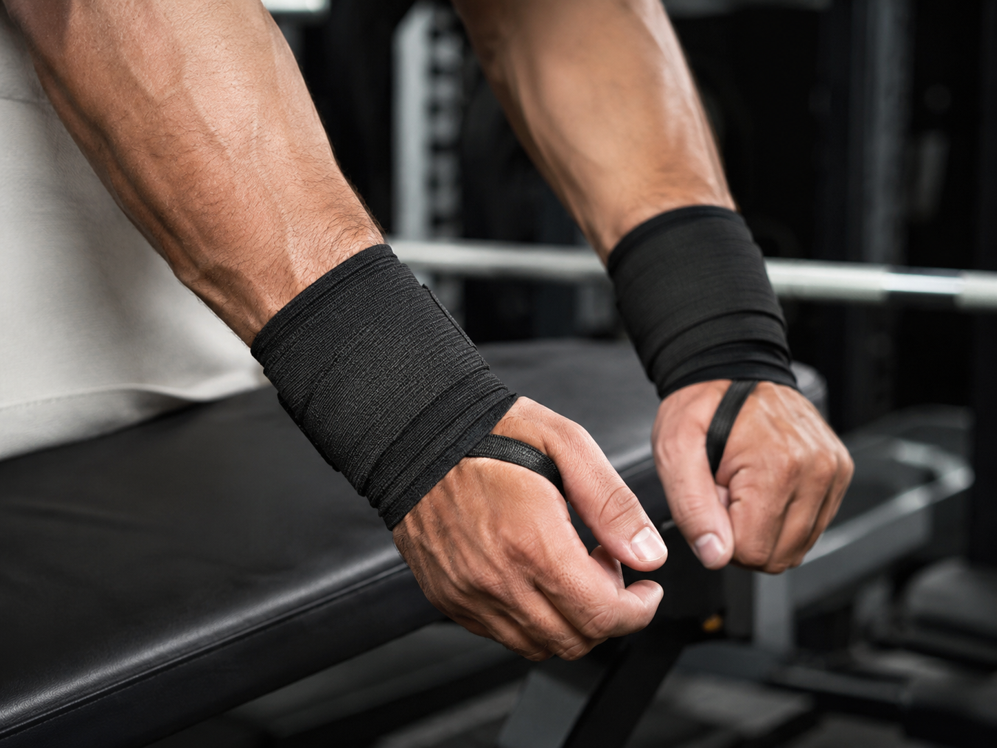 black wrist wraps on a man in the gym