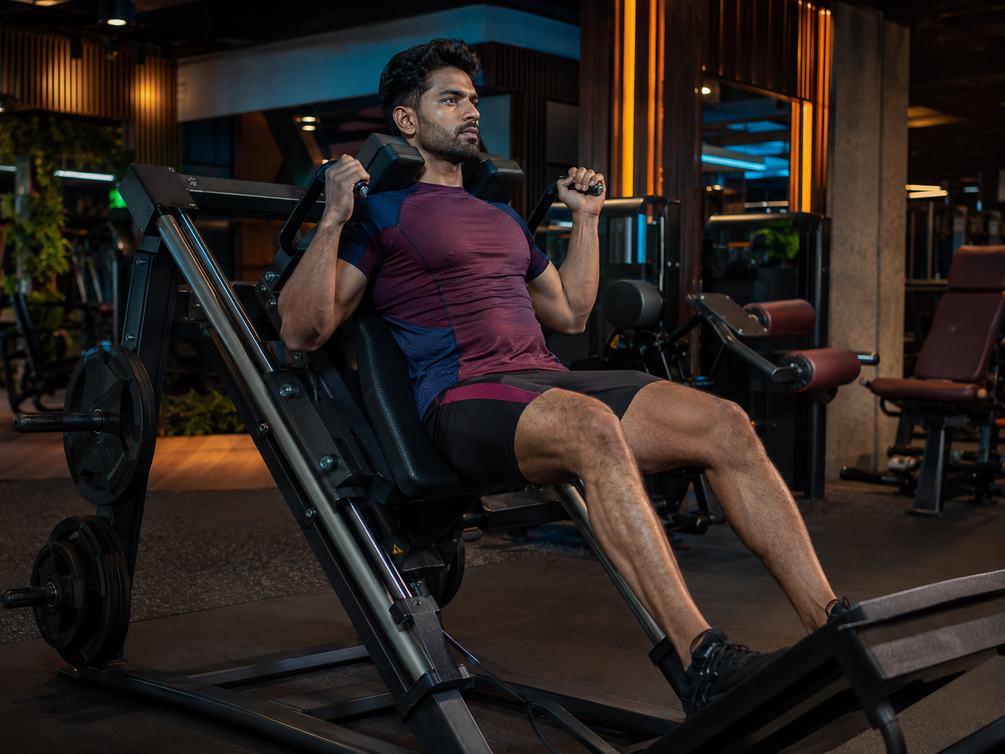 man performing a hack squat in the gym