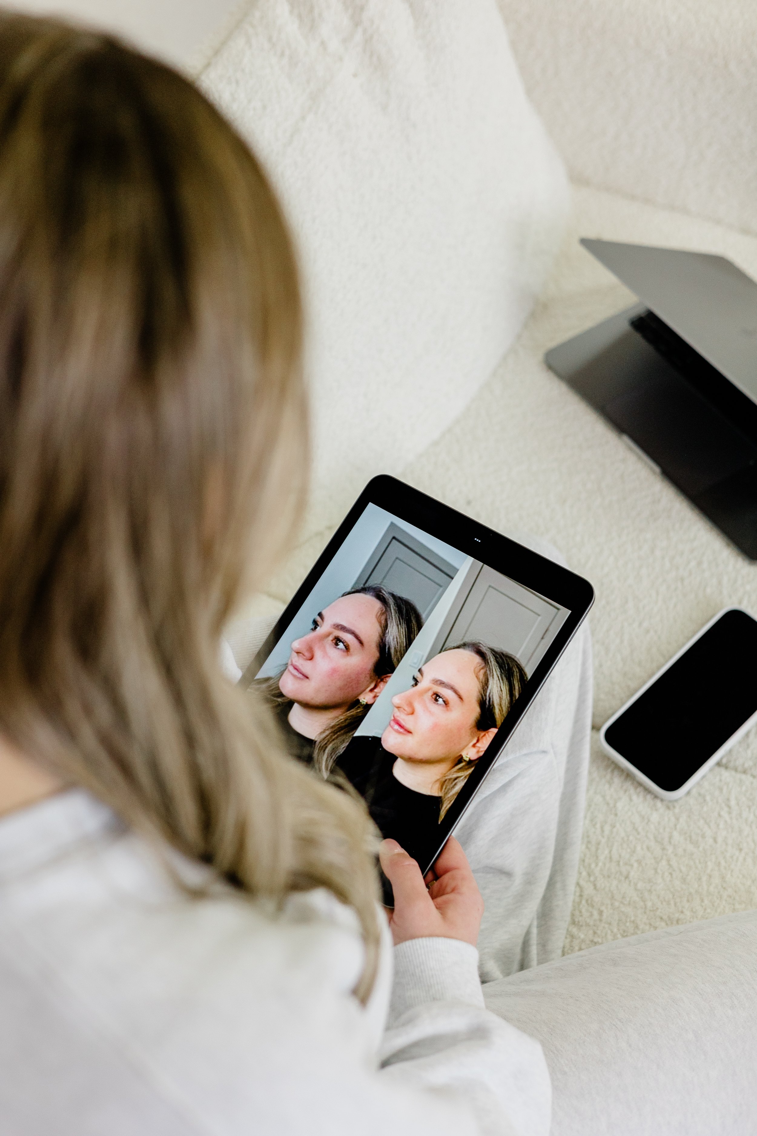 Woman holding beauty product boxes labeled 'Outline+' and 'Shape+'."