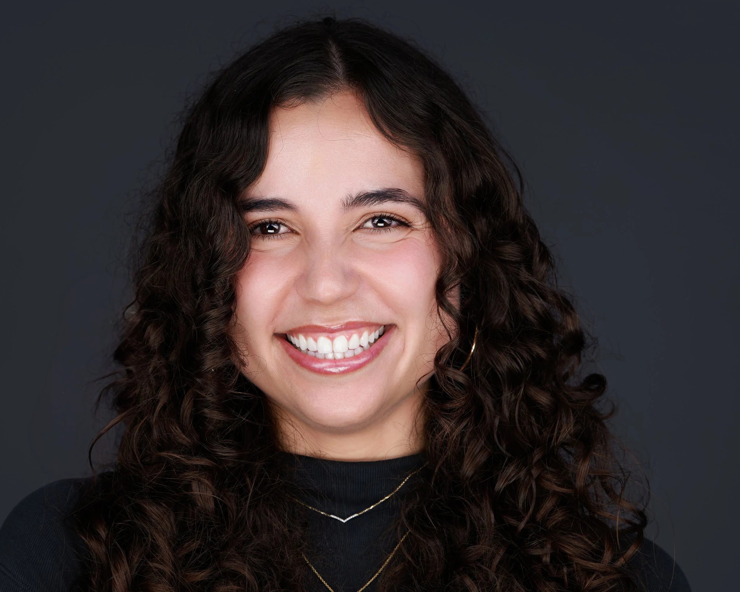 Confident, smiling woman posing for her headshot in Boston