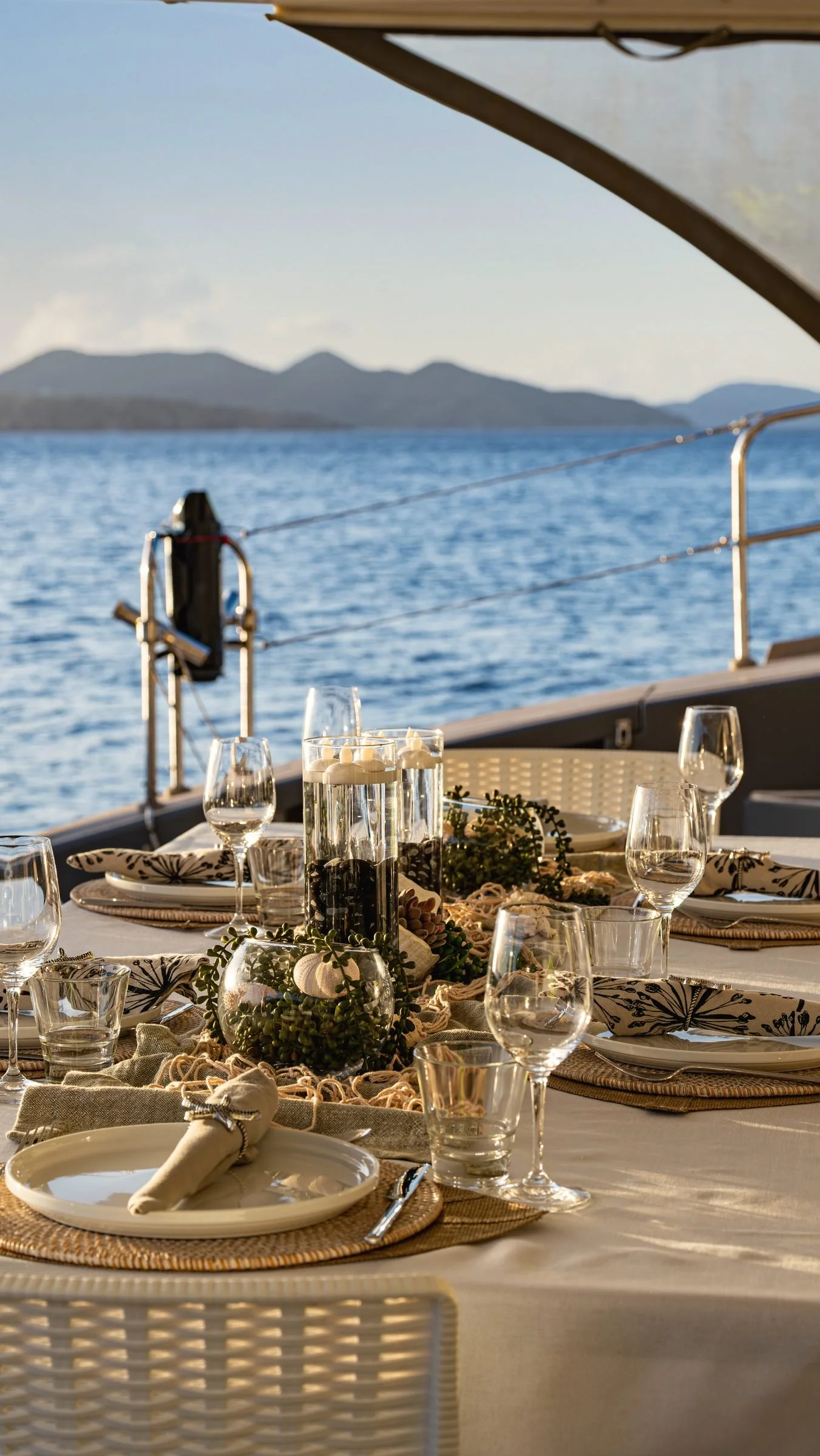 MAVERICK's dinner table set with glasses and place settings, the sea behind, BVI.