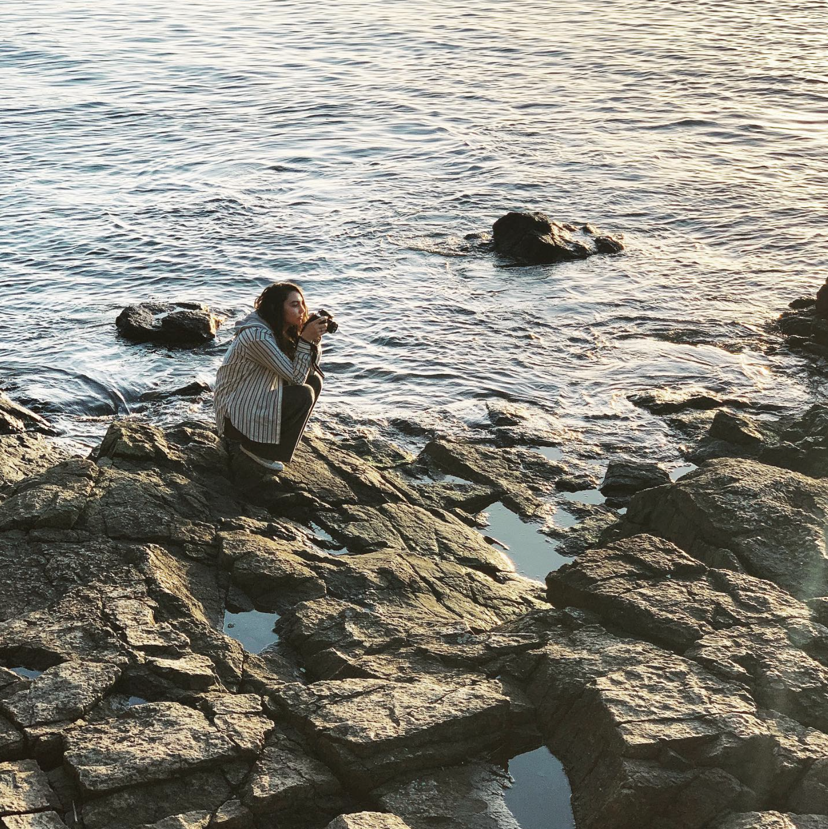 Portrait of Emma Jewell Barnett taking photos on the beach