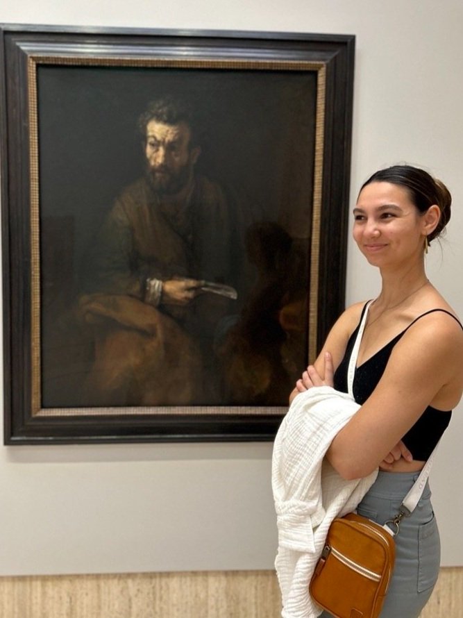 Portrait of Emma Jewell Barnett in a museum in front of a painting