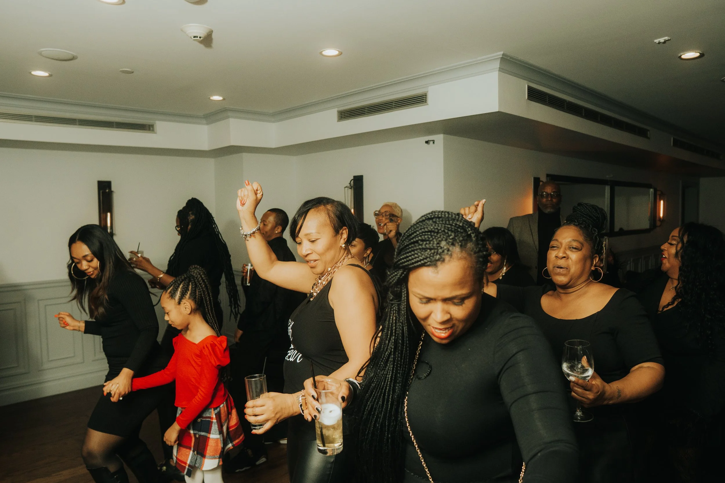People dancing and enjoying a party in a dimly lit room.
