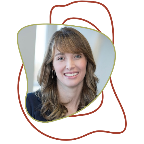 A woman with light brown, wavy hair and hoop earrings smiling at the camera.