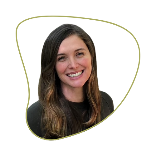 A smiling woman with long brown hair, wearing a black top, against a green background.