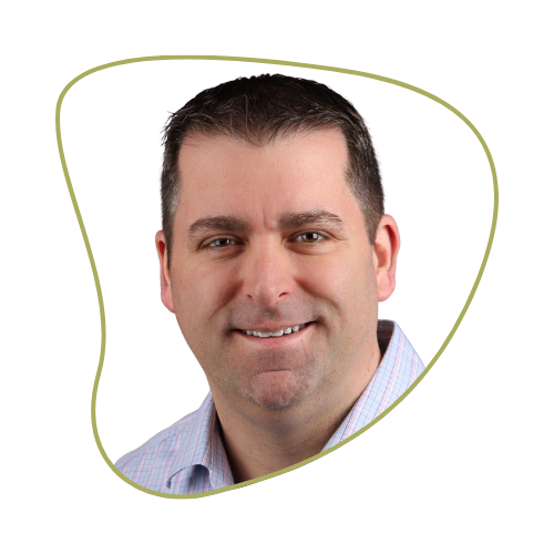 Close-up of a smiling man with short dark hair, wearing a light-colored collared shirt, against a green and black background.