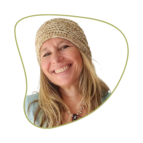 A smiling woman with long blonde hair, wearing a knitted beige beanie and a casual light-colored shirt, against a mostly transparent background.