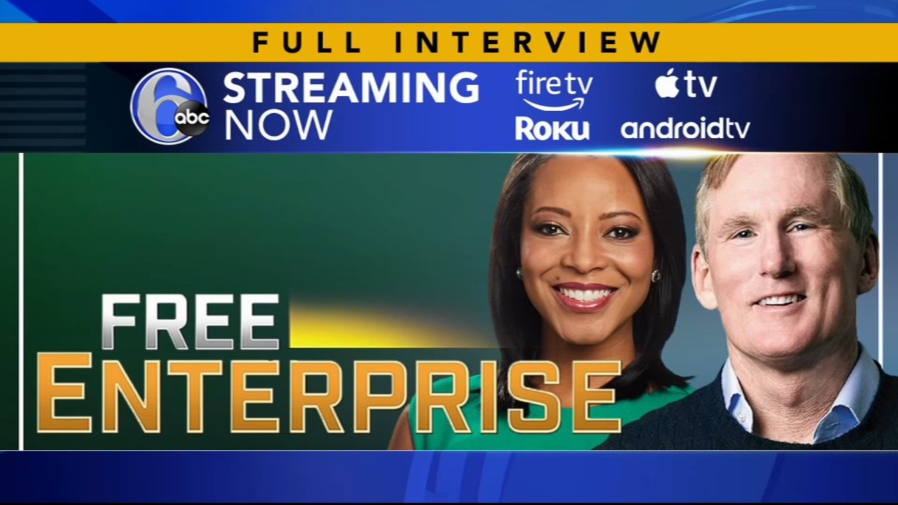 Promotional banner for "Free Enterprise" streaming on ABC 6, featuring headshots of a black woman and a white man. Includes logos for streaming platforms: Fire TV, Roku, Apple TV, and Android TV. The title "Full Interview" is highlighted at the top i