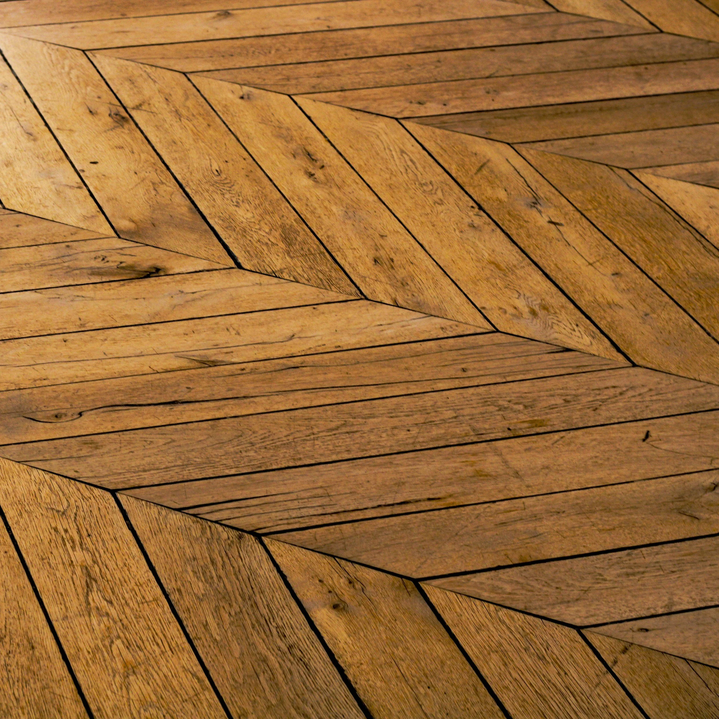 Close-up of a wooden floor with a herringbone pattern.