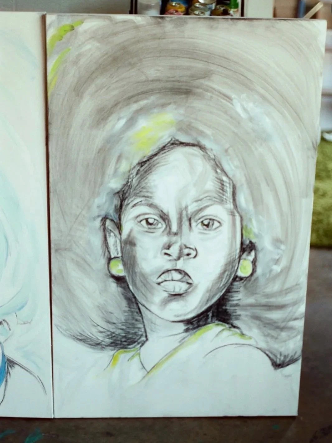 A portrait sketch of a young woman with earrings, drawn with charcoal and colored highlights, with an abstract background.