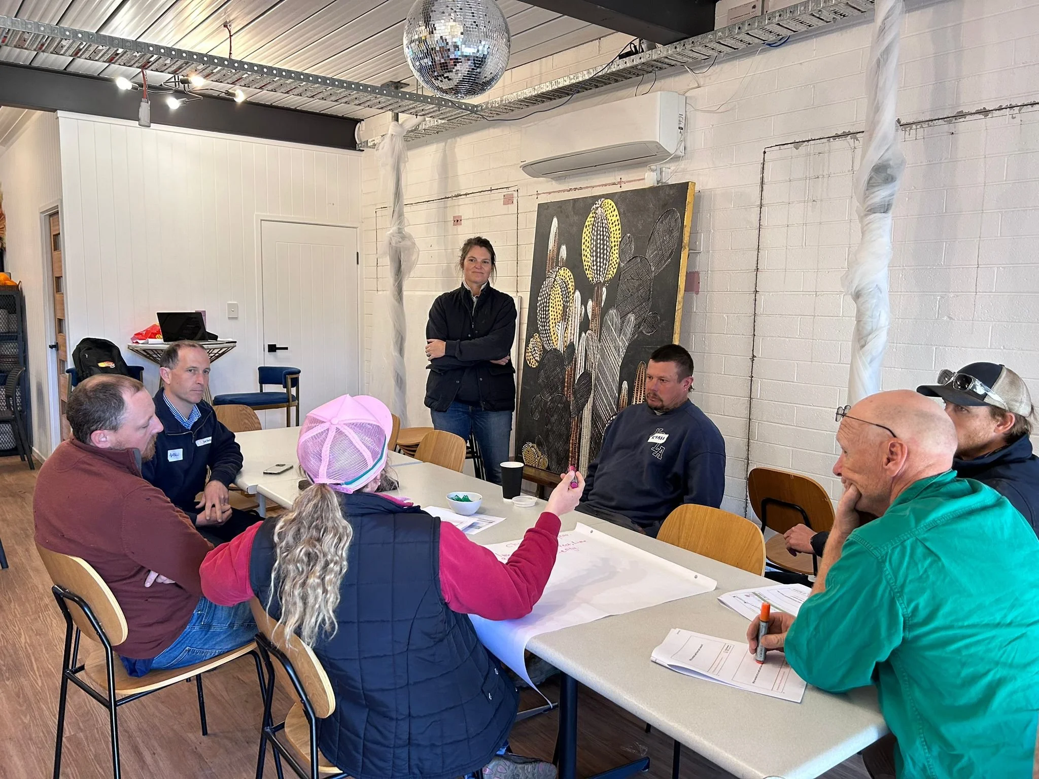 Group of people sitting around a table in a room for a Focus Site meeting