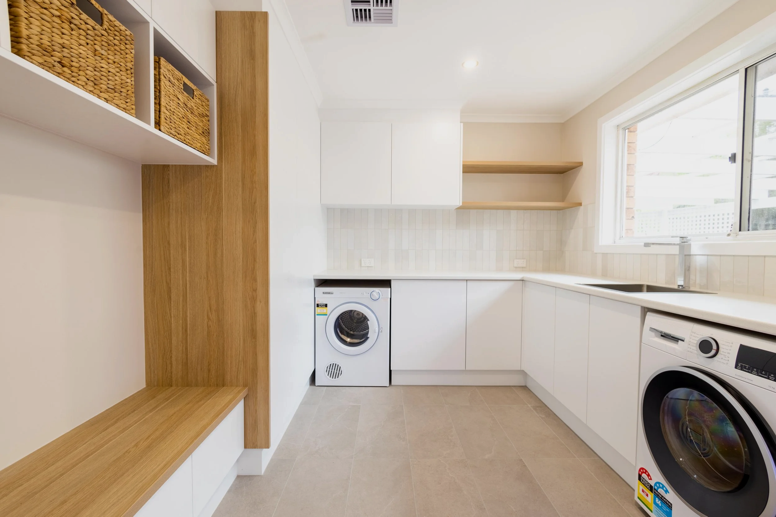 Laundry room with white cabinets and open wooden shelves Built by Jaymax Construction in Fadden Canberra