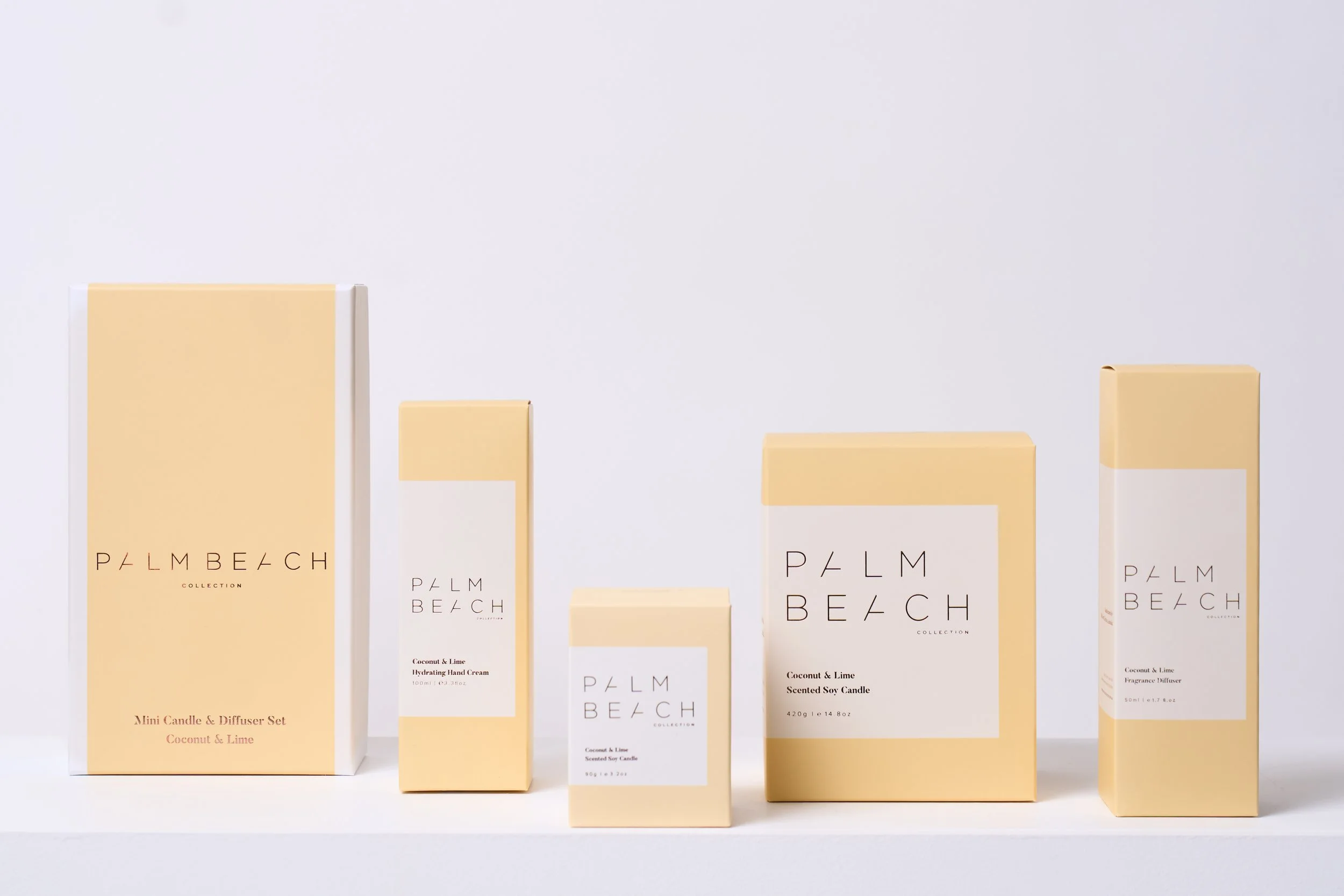 Collection of Palms Beach scented candles and diffusers in beige packaging on a white surface.