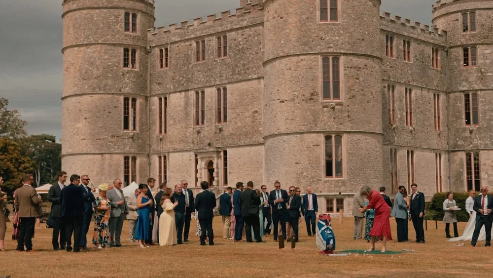 Guests enjoying a wedding reception on the lawn at Lulworth Castle in Dorset, filmed by Wedding Videographer Spice Wedding Films