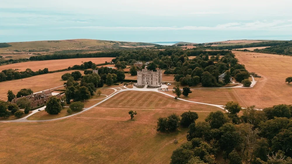 A drone shot of Lulworth Castle with the Dorset countryside in the background.