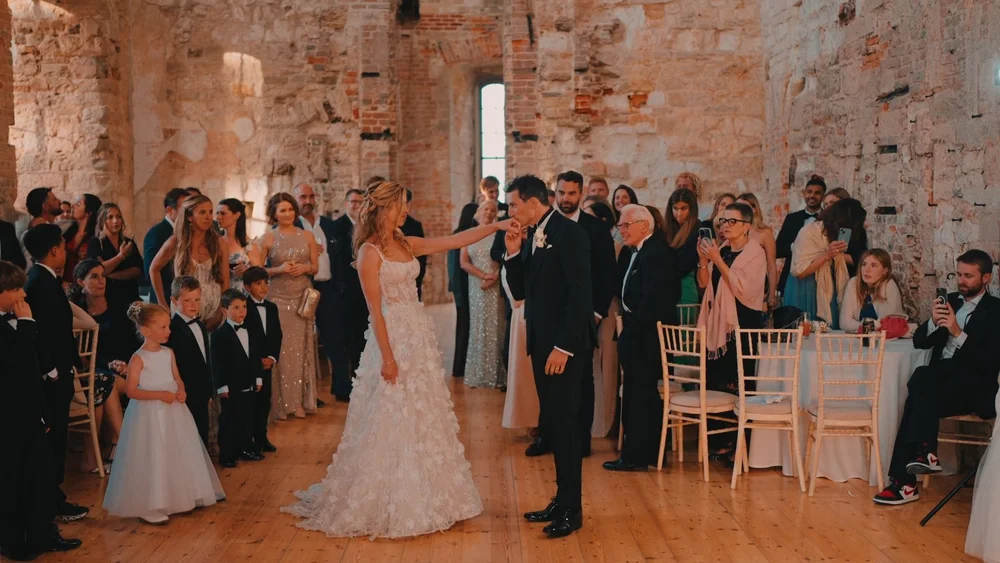 A couple begin their first dance within the stone walls of Lulworth Castle in dorset, filmed by spice wedding films
