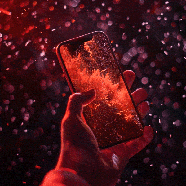 A hand holding a smartphone with a fiery red and orange explosion display on the screen, surrounded by glowing bokeh lights.