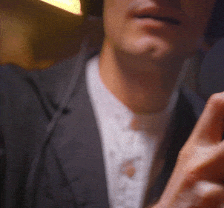 Close-up of a man in a suit using a smartphone.