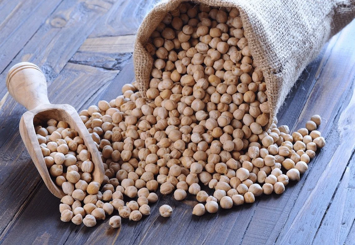 Cecioli di nocciole in un sacco di tessuto, con una paletta di legno.