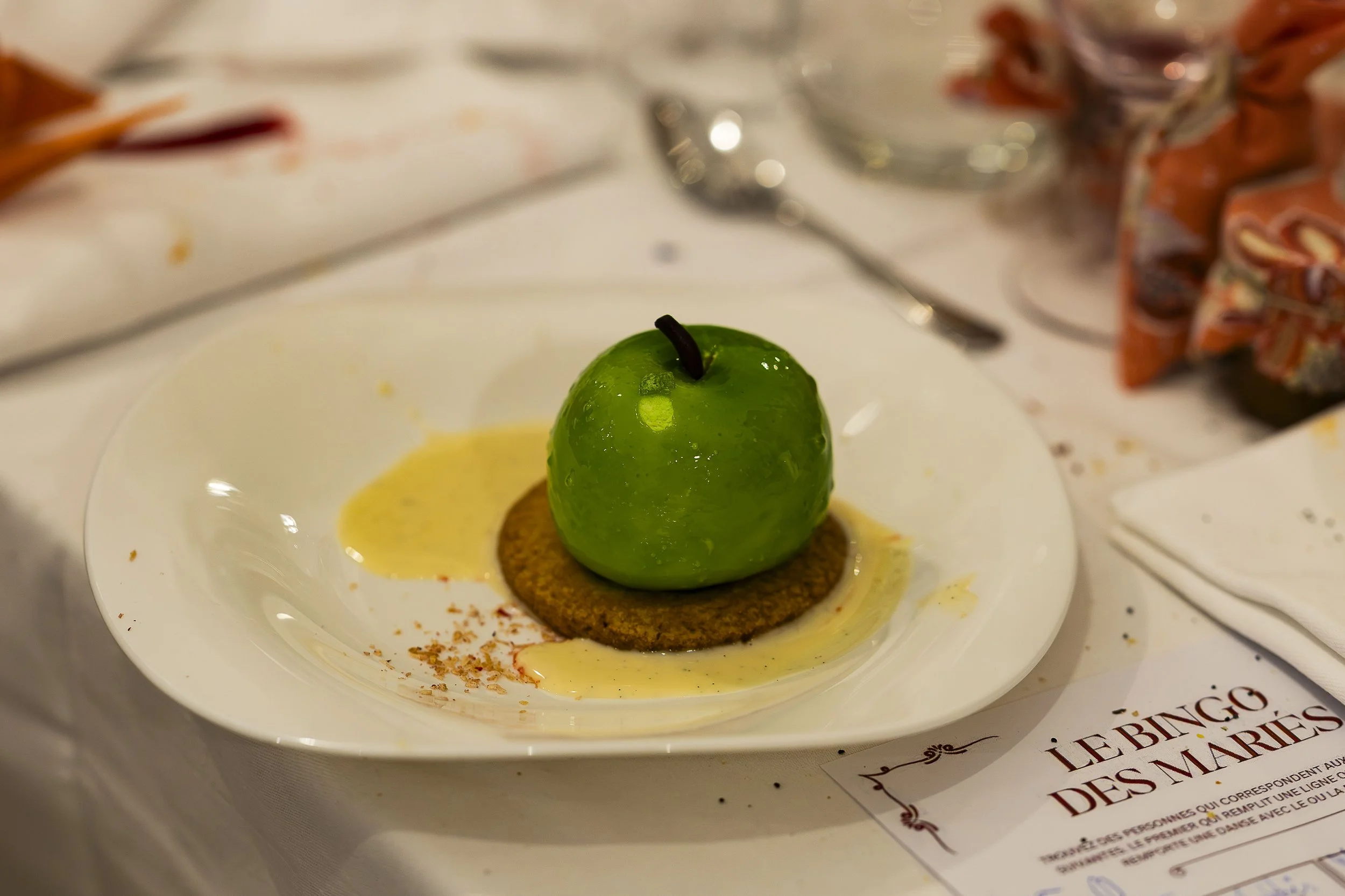 Une tartelette avec une grosse pomme verte en dessus, décorée pour ressembler à une pomme réelle.
