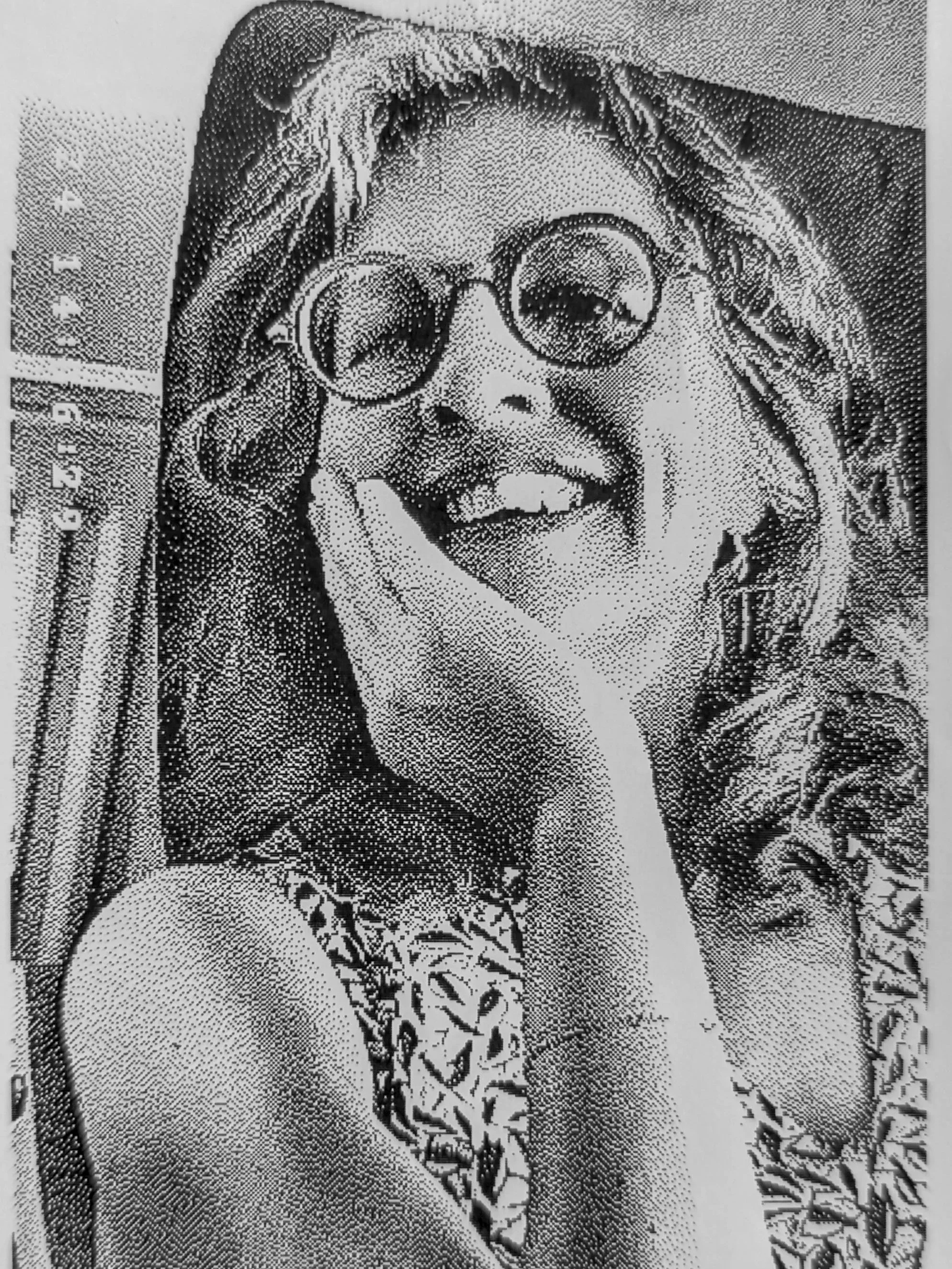 Portrait stylisé d'une femme portant des lunettes rondes, faisant un geste en forme de 'peace' avec la main, en noir et blanc avec un effet pointillé.