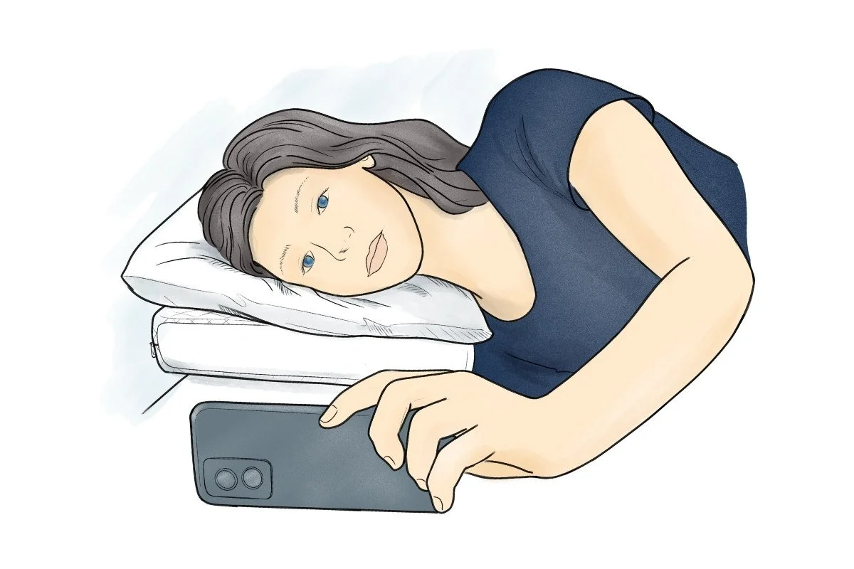 Person resting on two pillows, using a camera phone to check their head, neck and spine are in good alignment