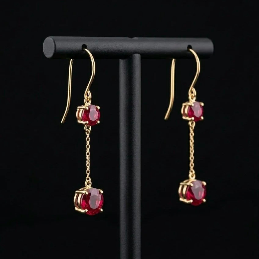 Boucles d'oreilles en or avec deux pierres précieuses rouges suspendues par une chaîne