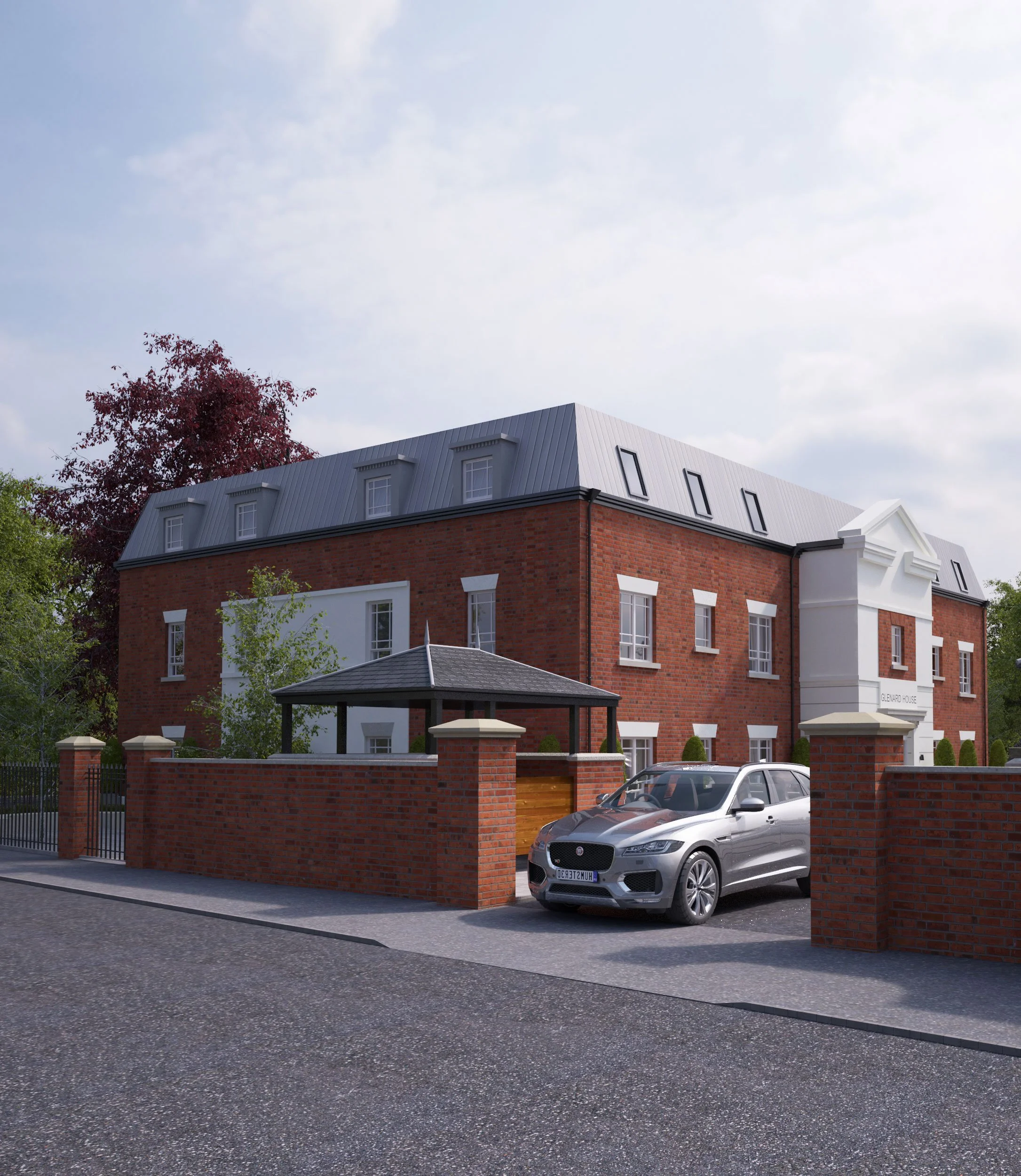 Asiko Architects Ltd — A large red brick building with a gray metal roof and white accents. It has multiple windows and a small entrance with a white portico. A black gate s