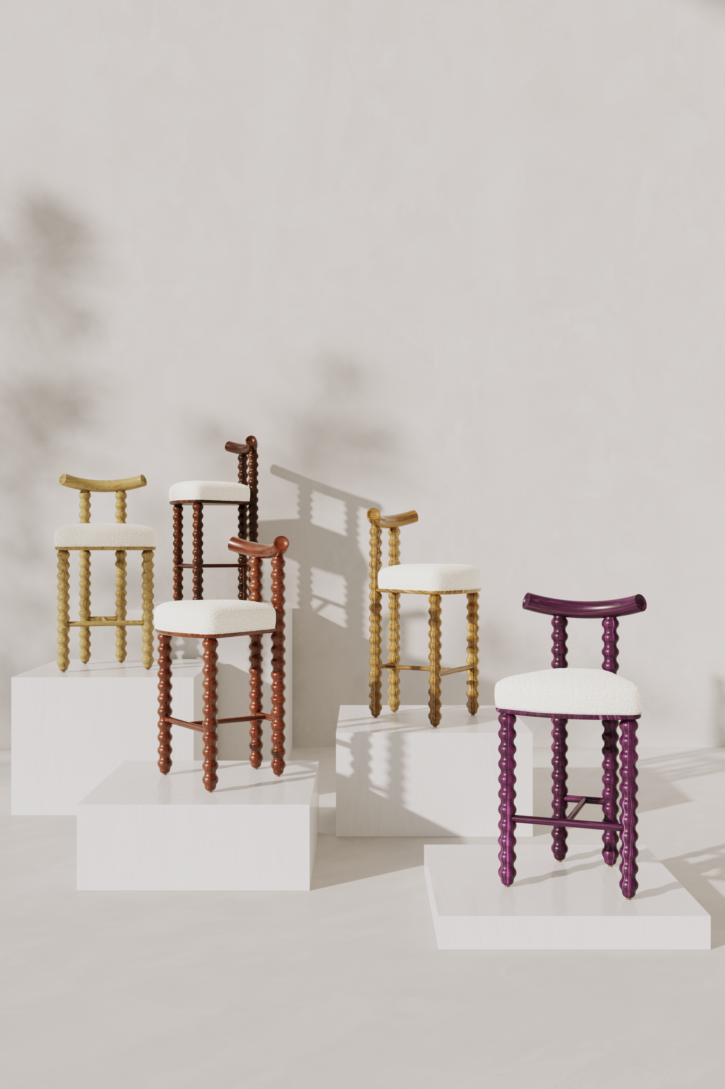 Five colorful wooden chairs with white cushions displayed on white platforms against a light background.