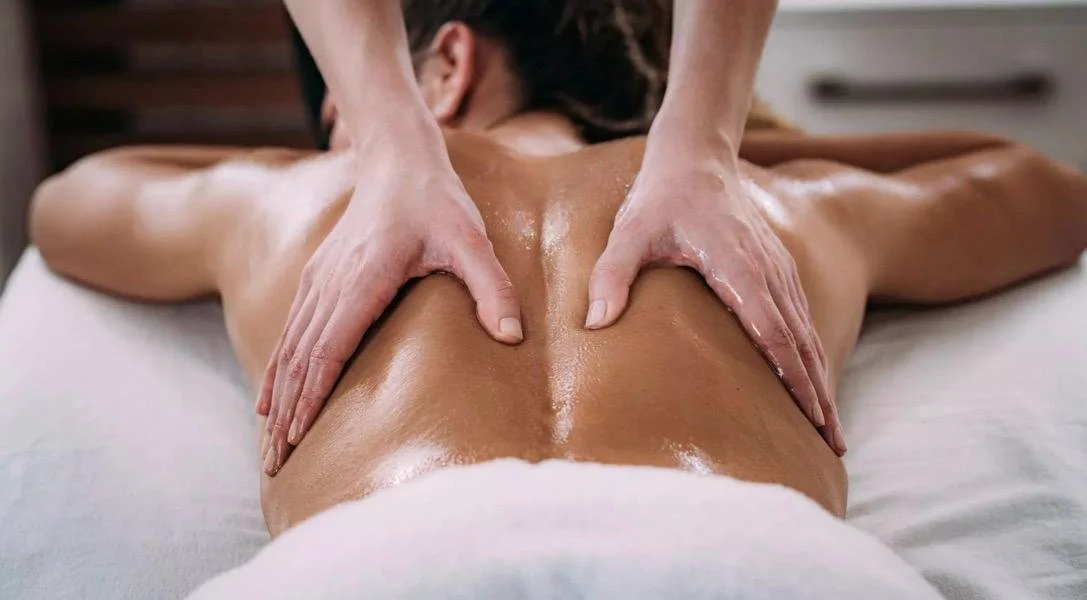 A person receiving a back massage with oil on their back
