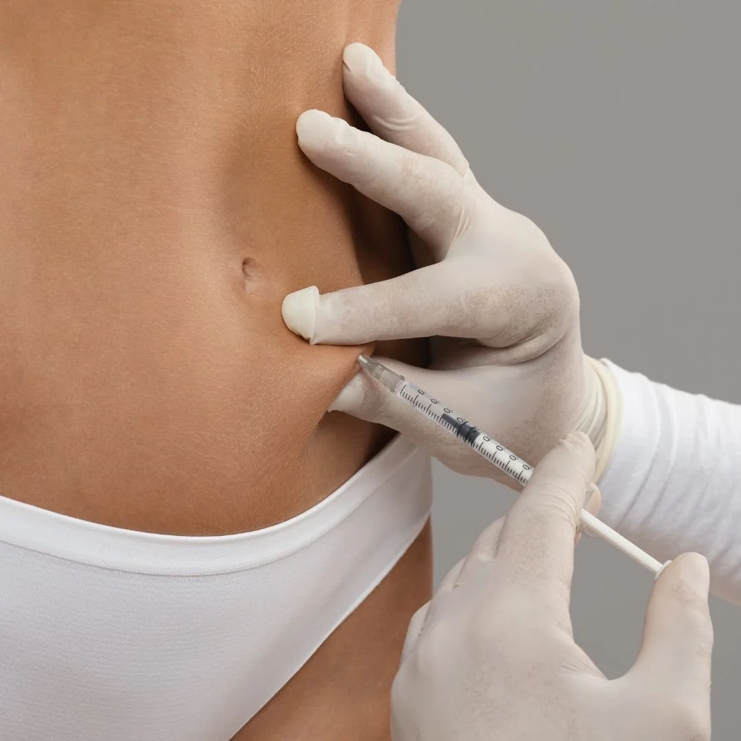 Person receiving abdominal injection by medical professional wearing gloves.