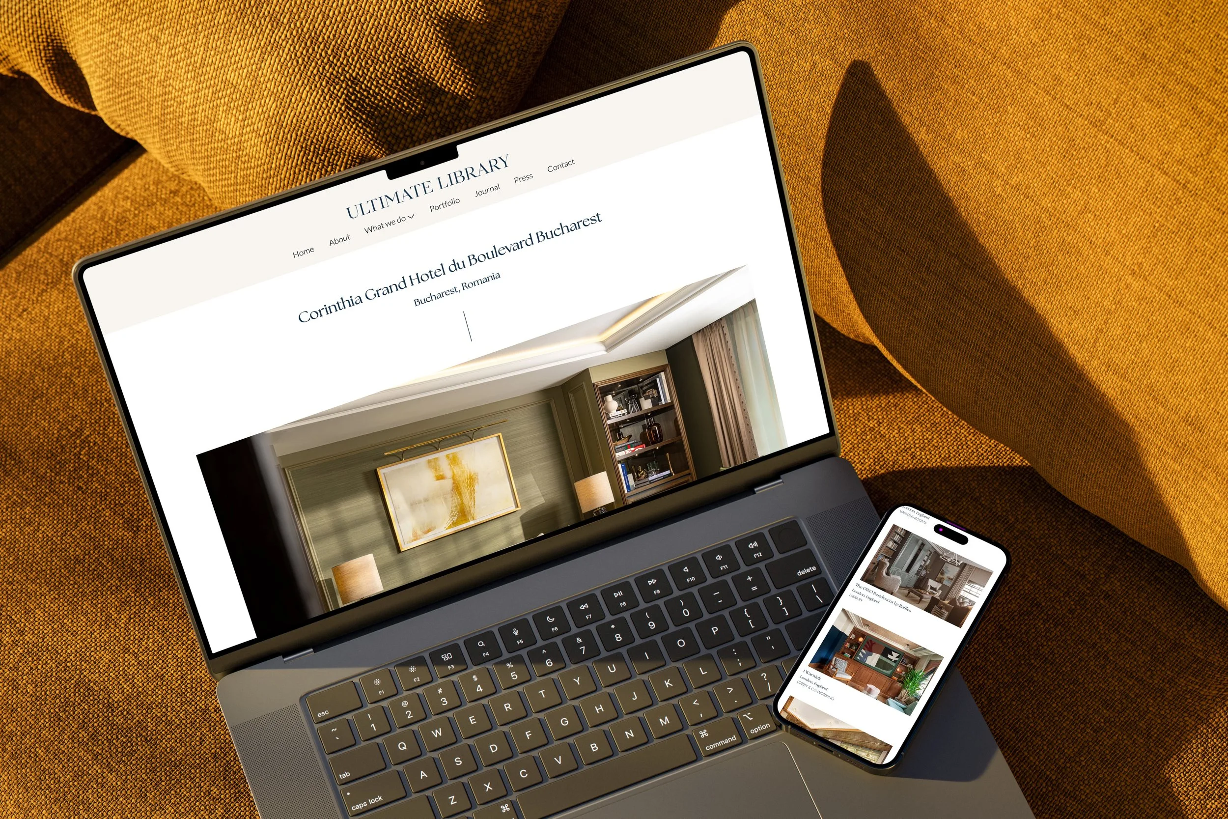 Open laptop and smartphone displaying interior design images, placed on a textured brown sofa.