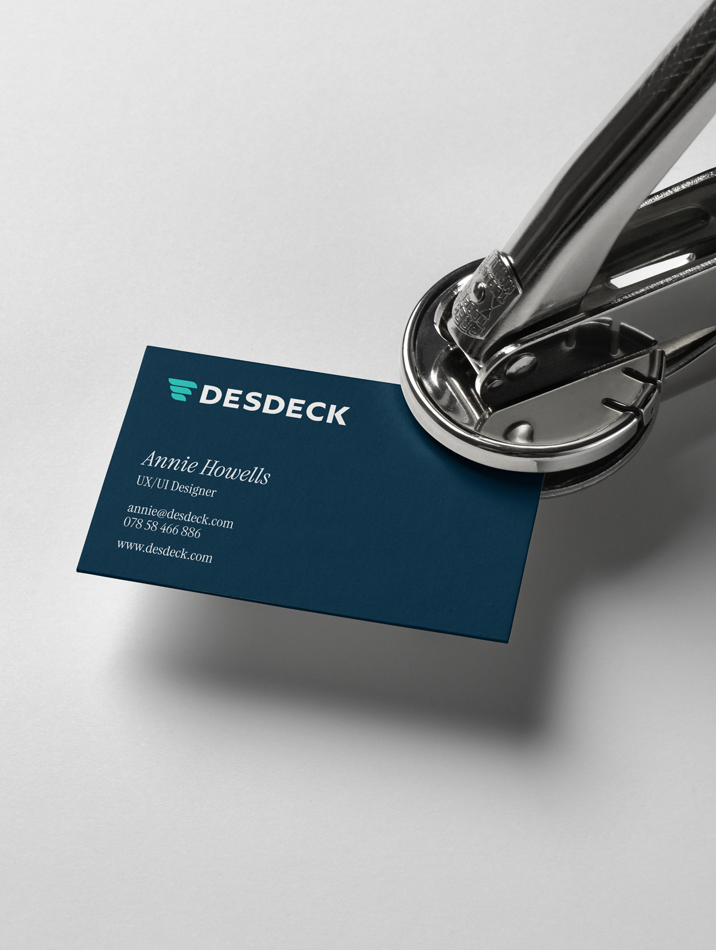 Business card being stamped with a metal business card stamp with a business logo and contact information.