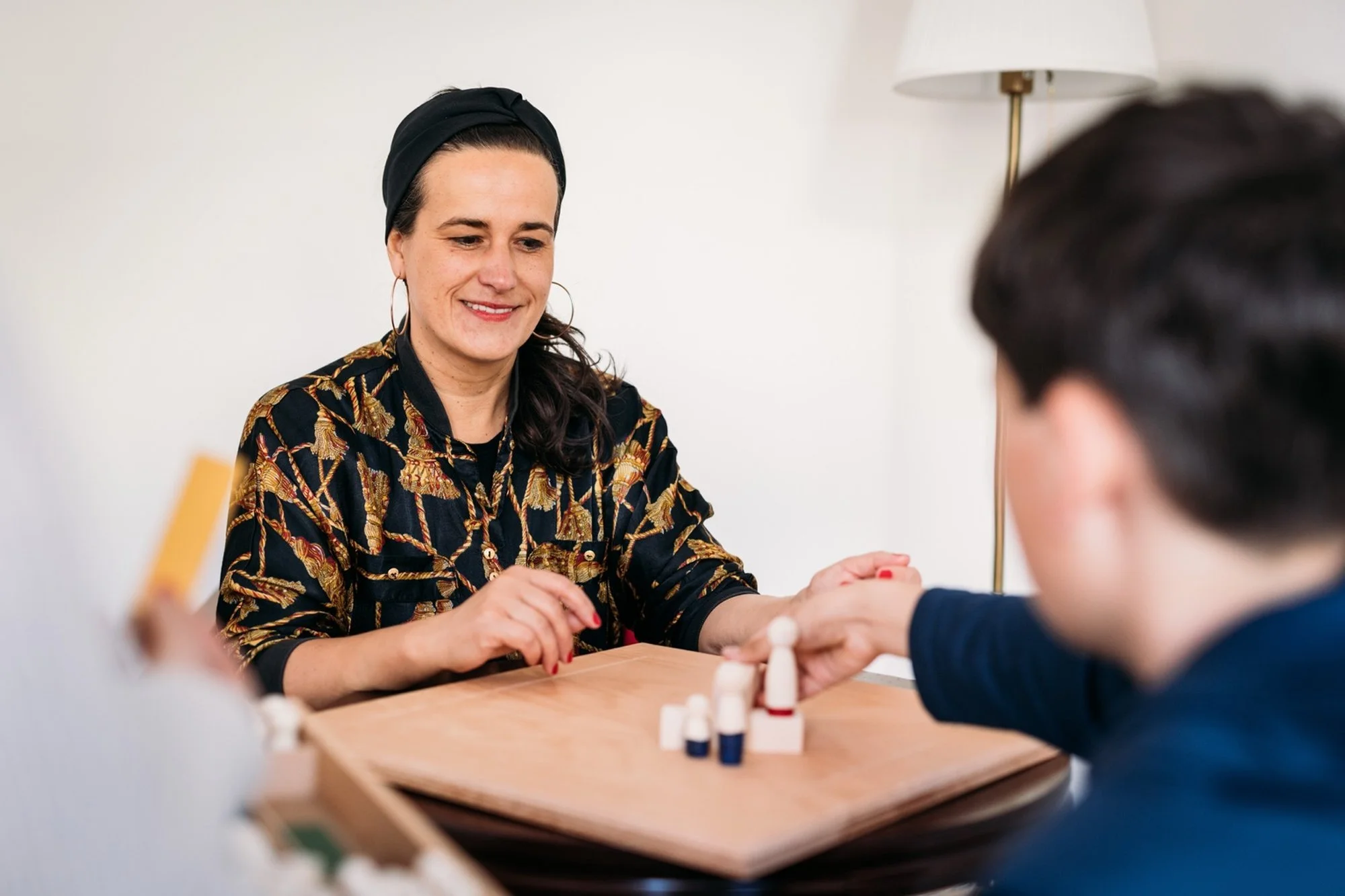 Julia Pfeifer in therapeutischer Arbeit mit einem Kind und Figuren auf dem Tisch.